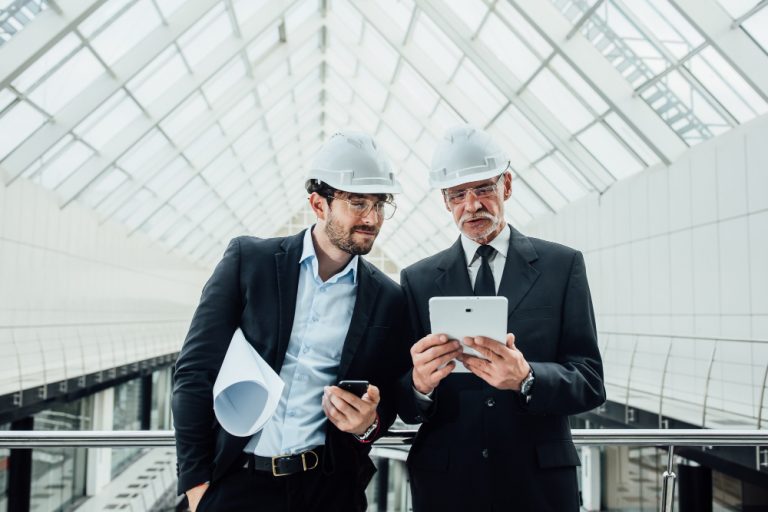 two-successful-entrepreneur-helmet-with-project-laptop-new-buildings-stay-near-glass-roof.jpg